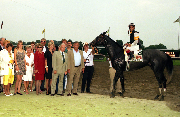 Holy Bull and connections in the winner's circle after the 1994 Haskell. Bill Croll, tan suit, no tie; Jimmy Croll, tan suit, tie; Billie Rae Croll, black and white sleeveless dress. Photo: Equi-Photo