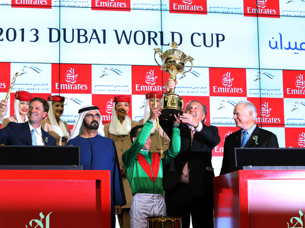 Jockey Joel Rosario and Arrowfield Stud's John Messara hoist the winner's trophy following the 2013 Dubai World Cup. Photo: RacingFotos.com.