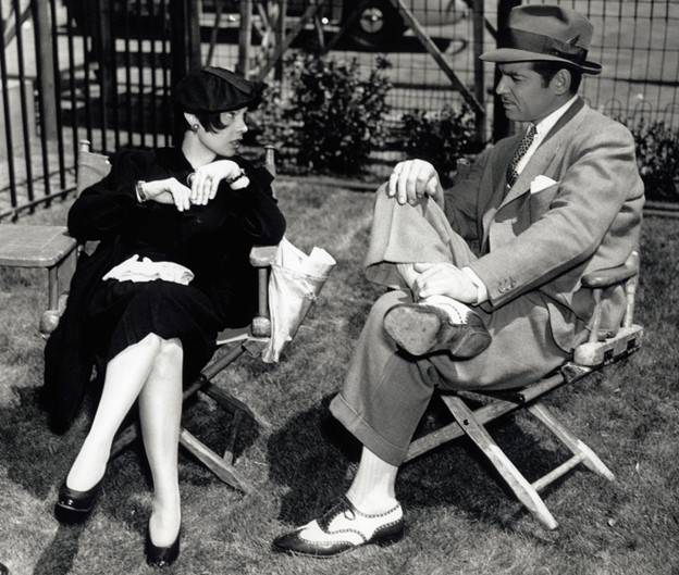 Screenwriter Anita Loos and Clark Gable lounge between takes on the Saratoga set. (MGM photo)