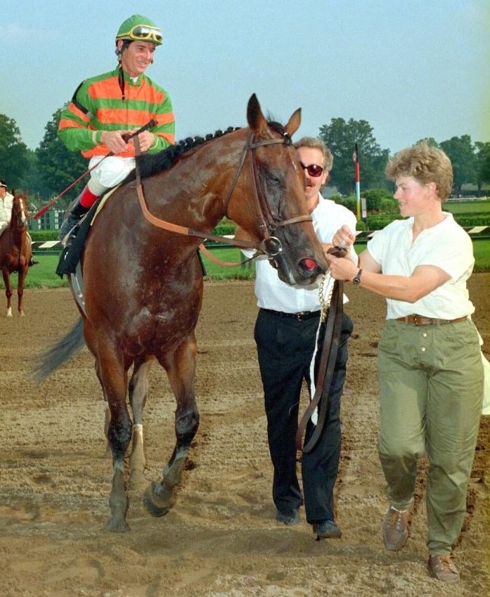 Craig Perret, co-owner Barry Weisbord, and groom Janet Maloney surround their star after the Test Stakes. (Coglianese photo)