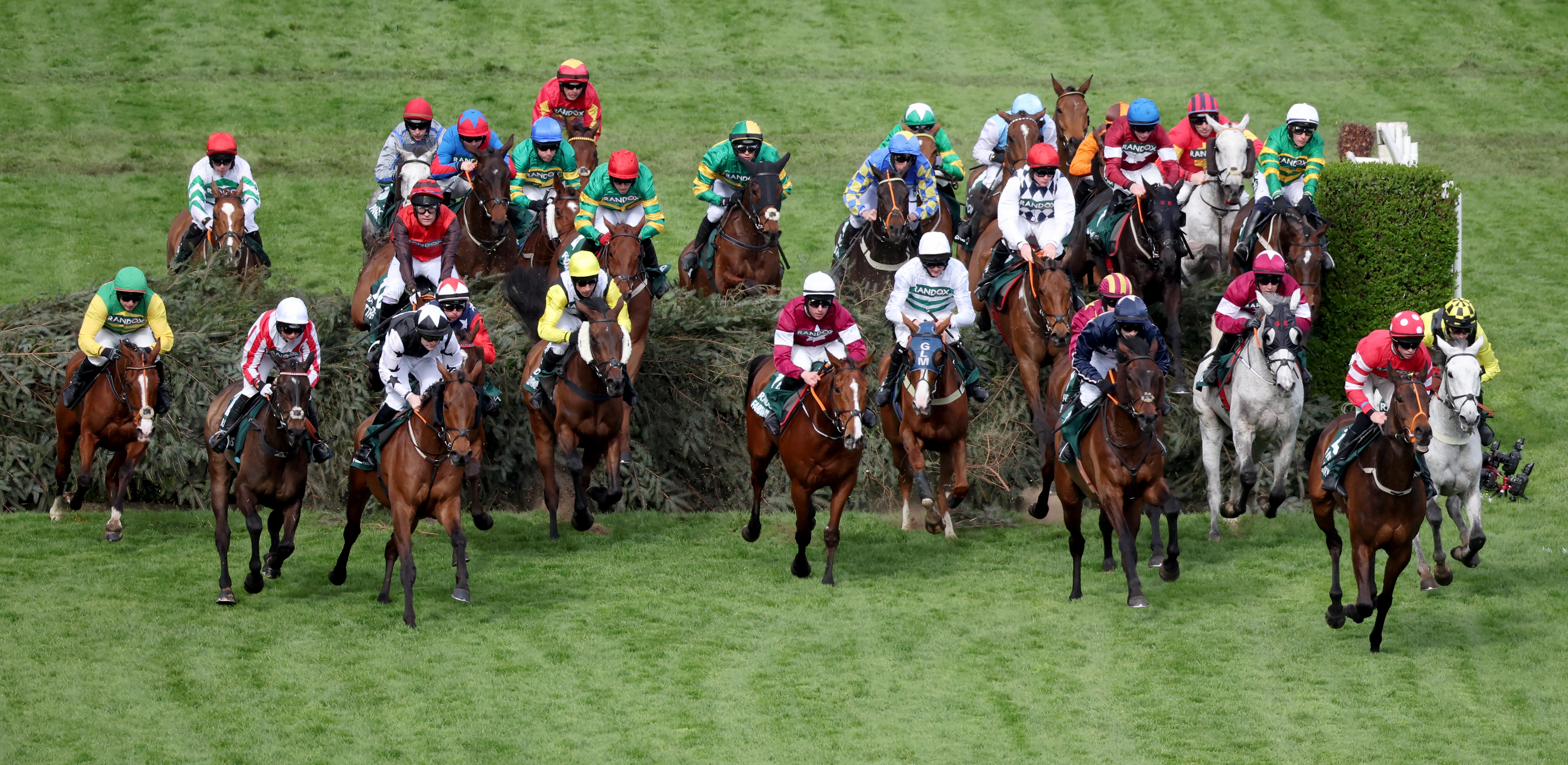 David Maxwell jumping the second-last on Ain’t That A Shame (red and brown silks, jumping) in the Grand National at Aintree. Photo: Mark Cranham / focuonracing.com