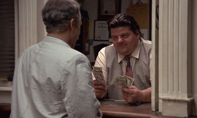 Robbie Coltrane’s skeptical teller becomes a big Trotter fan. (Paramount photo)